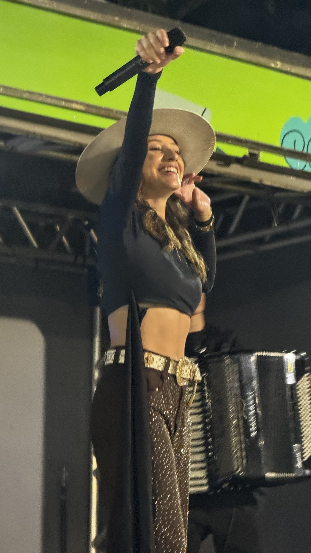 Giovanna interagindo com o público, de braço erguido durante o show